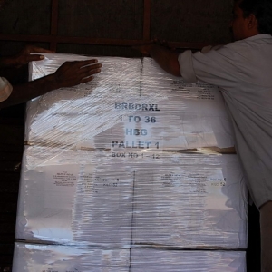 Workers shrink wrapping a pallet
